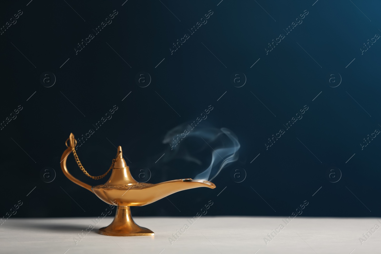 Photo of Aladdin lamp of wishes on table against dark background