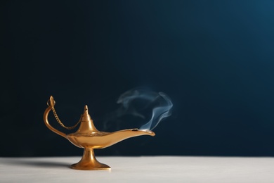 Photo of Aladdin lamp of wishes on table against dark background