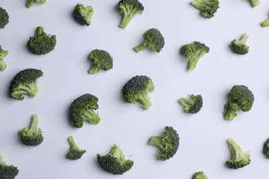 Many fresh green broccoli pieces on white background, flat lay