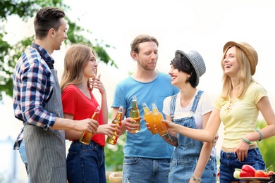 Photo of Young people with bottlesbeer outdoors. Summer picnic