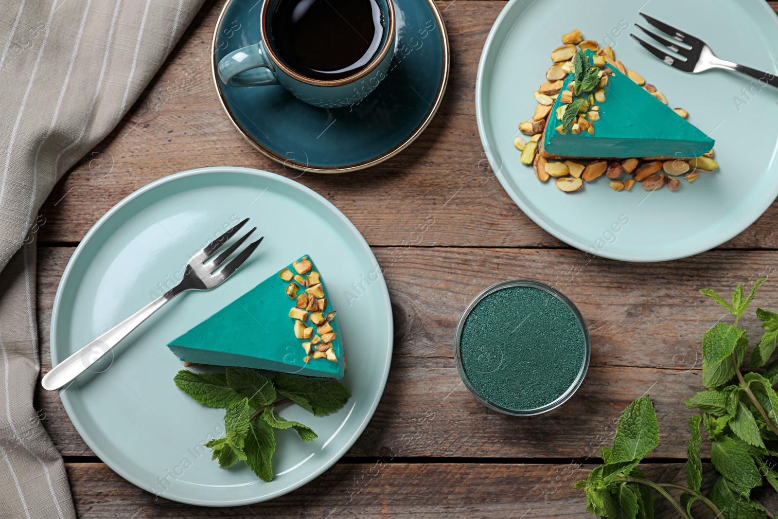 Photo of Flat lay composition with tasty spirulina cheesecake on wooden table