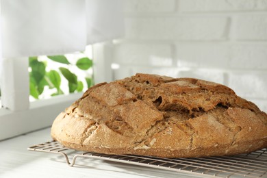 Photo of Freshly baked sourdough bread on white wooden table indoors