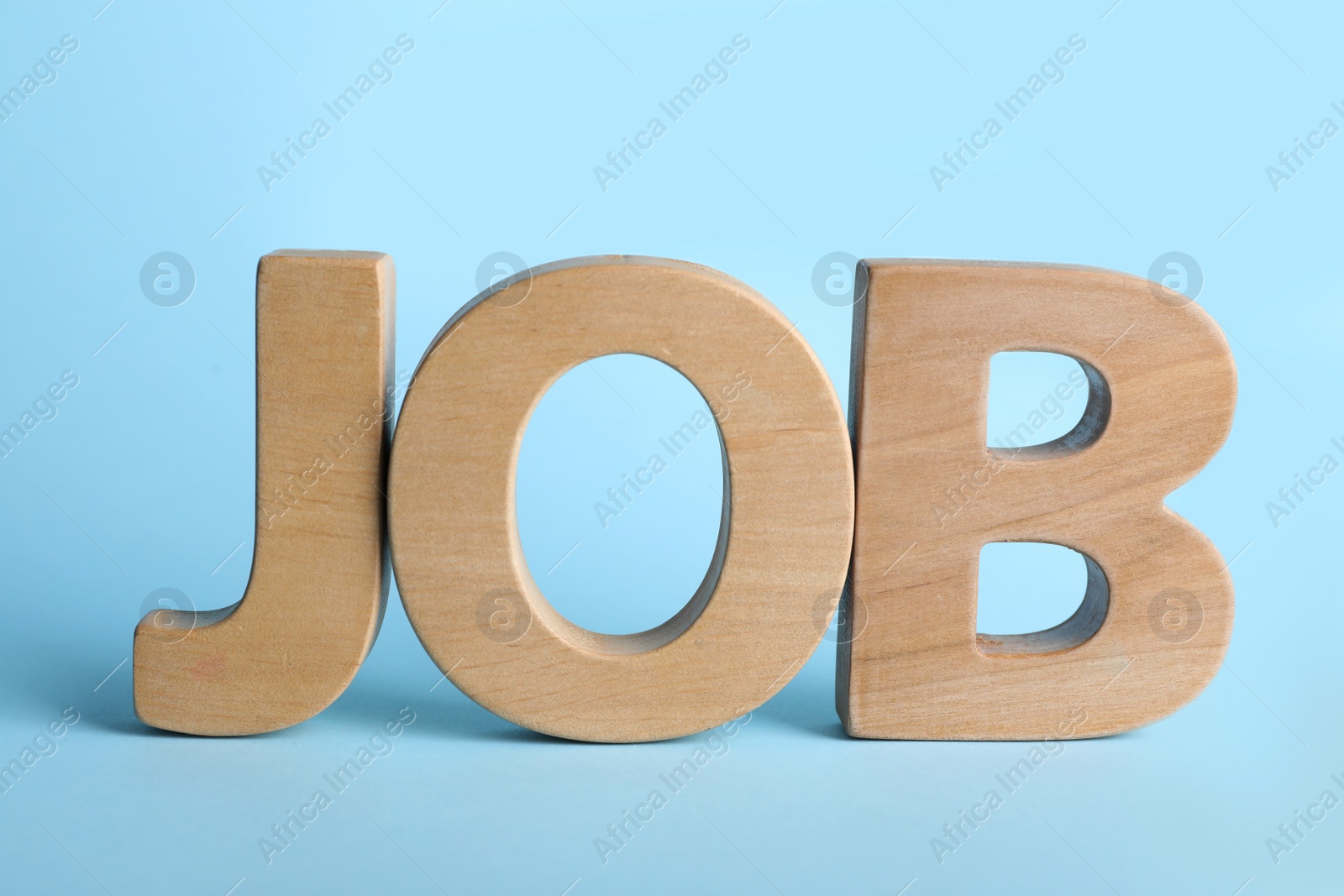 Photo of Word JOB made with wooden letters on light blue background. Career concept