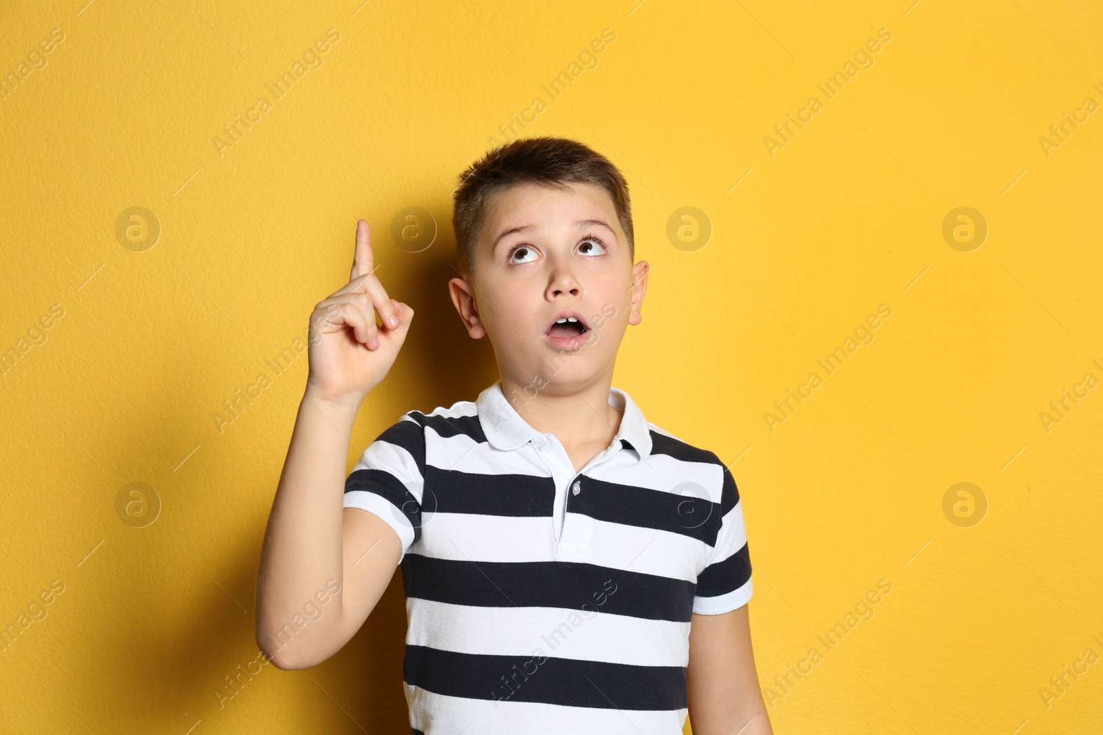 Photo of Portrait of emotional preteen boy on yellow background