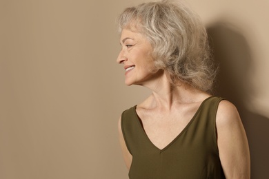 Portrait of mature woman on color background. Space for text