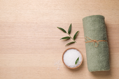 Photo of Flat lay composition with green towel on wooden table, space for text. Spa treatment