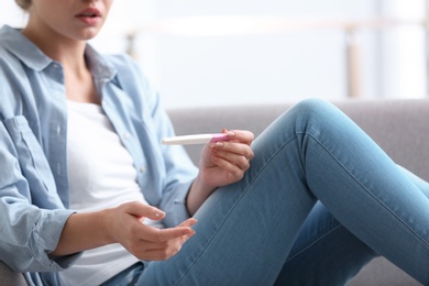 Photo of Young woman with pregnancy test at home. Gynecology