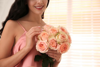 Photo of Young woman with beautiful bouquet indoors, closeup