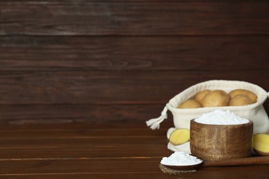 Starch and fresh raw potatoes on wooden table. Space for text