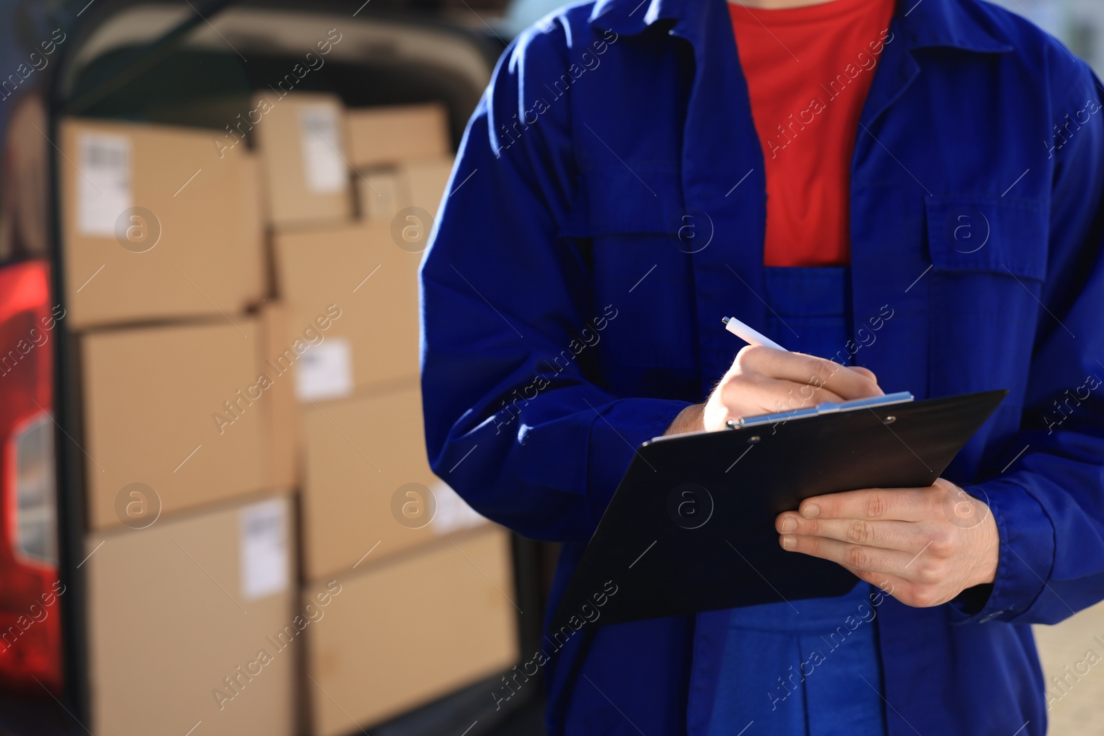 Photo of Courier with clipboard near delivery van outdoors, closeup. Space for text