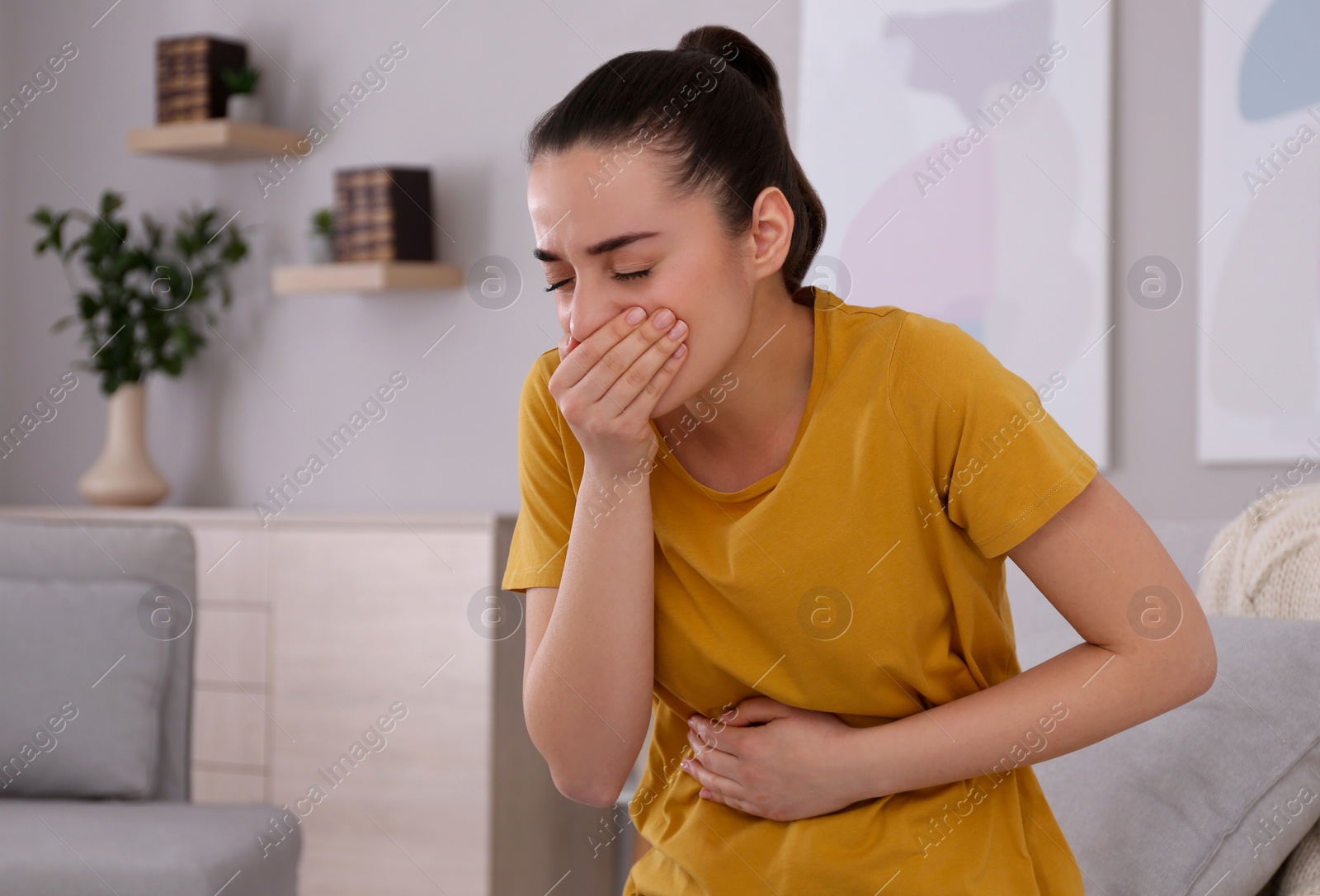 Photo of Young woman suffering from nausea at home. Food poisoning