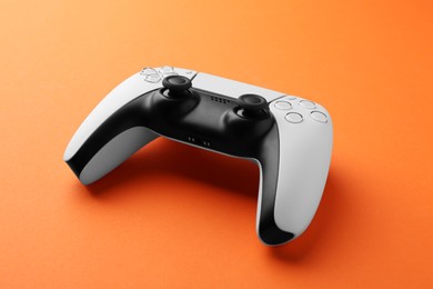 Photo of One wireless game controller on orange background