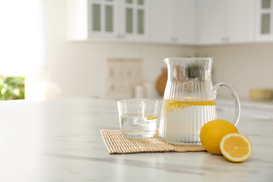Photo of Fresh lemonade on white marble table in kitchen