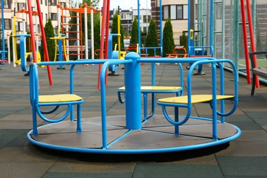 Photo of Empty outdoor children's playground with merry-go-round in residential area