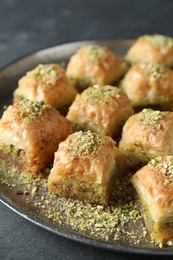 Photo of Delicious fresh baklava with chopped nuts on grey table, closeup. Eastern sweets