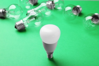 Photo of LED and incandescent lamp bulbs on green background