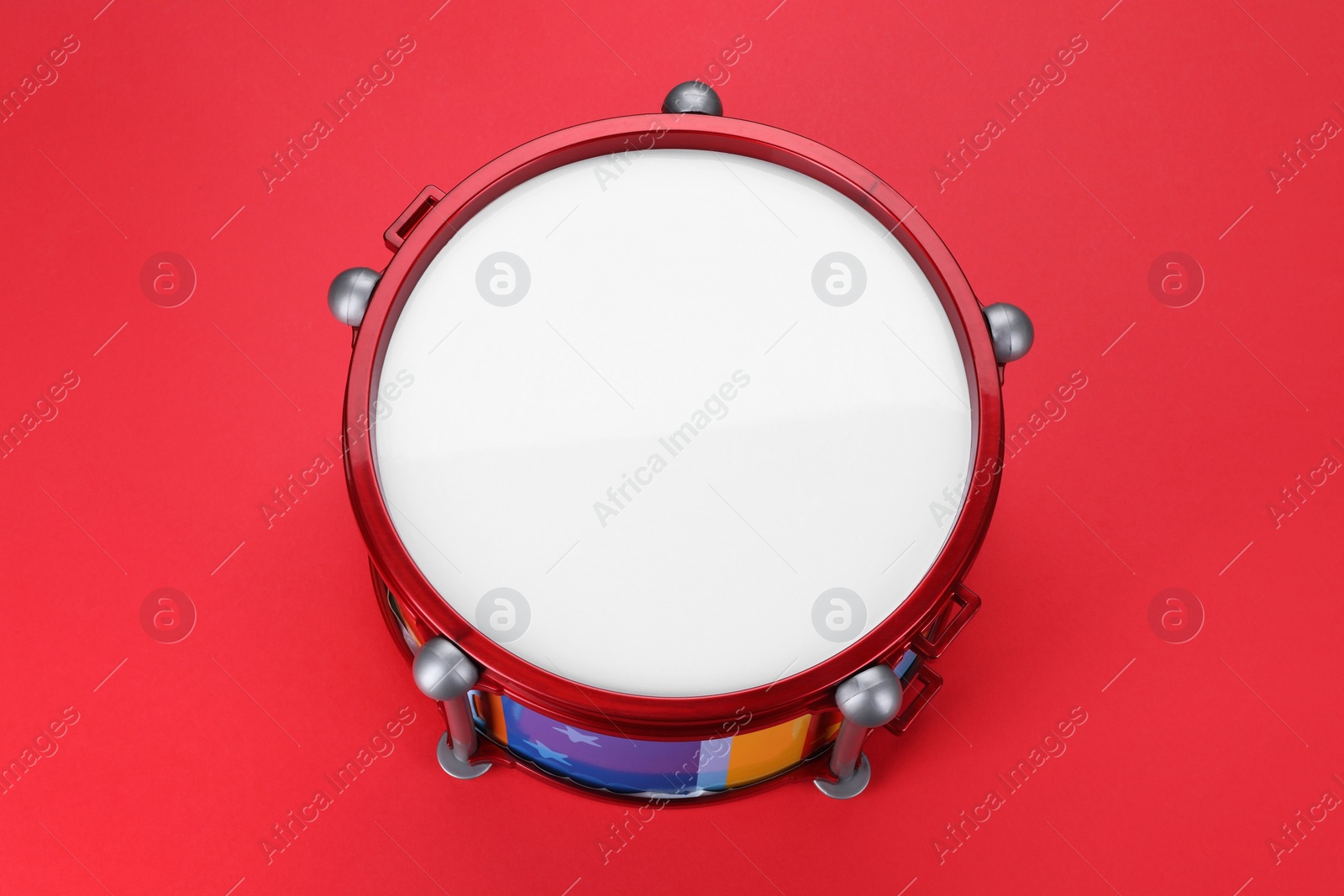 Photo of Drum on red background, above view. Percussion musical instrument
