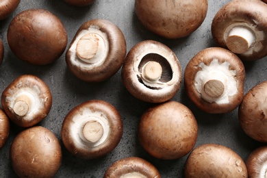 Photo of Fresh champignon mushrooms on grey background, flat lay