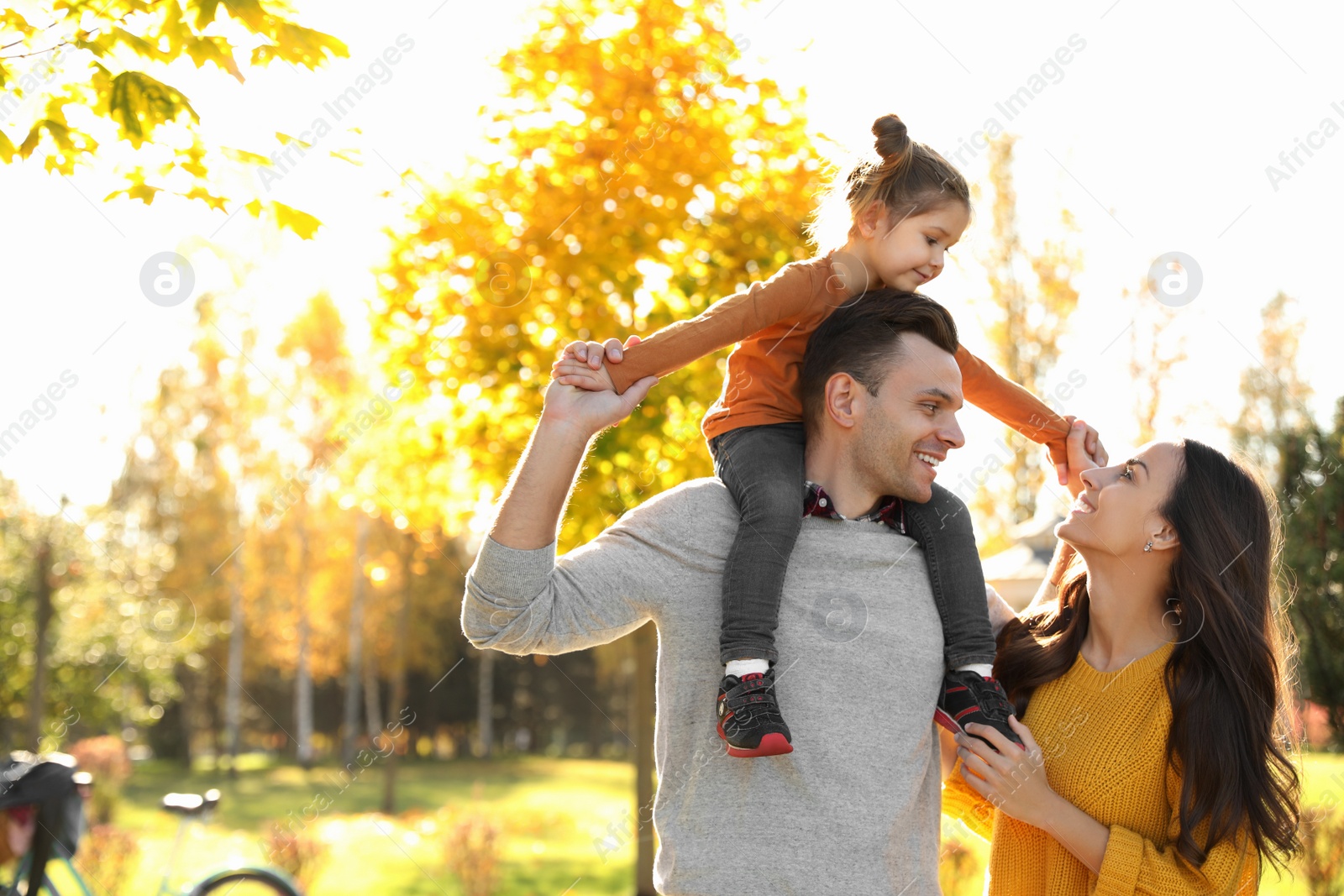 Photo of Happy family with little daughter in park. Autumn walk