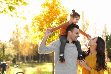 Happy family with little daughter in park. Autumn walk