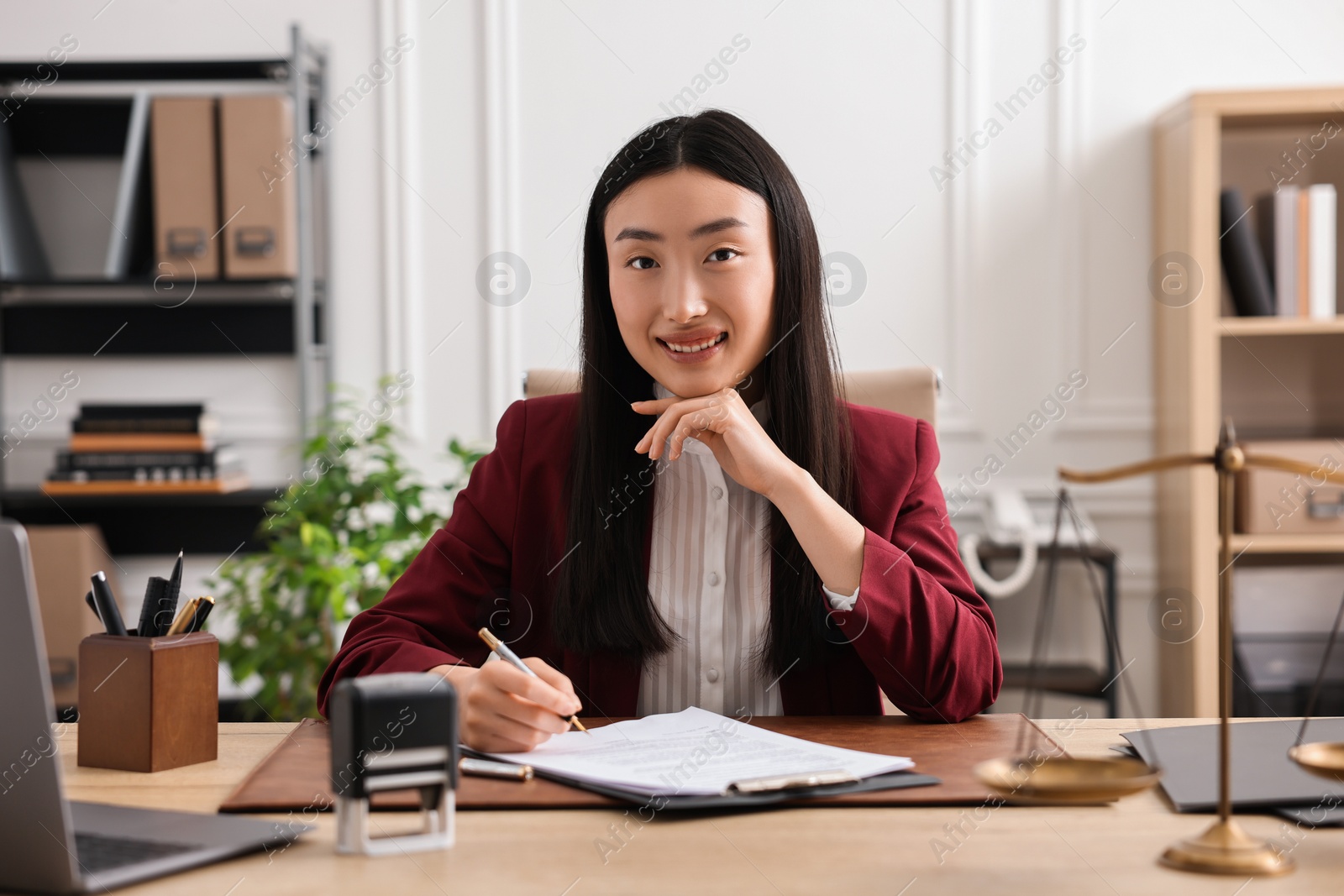 Photo of Portrait of smiling notary at table in office