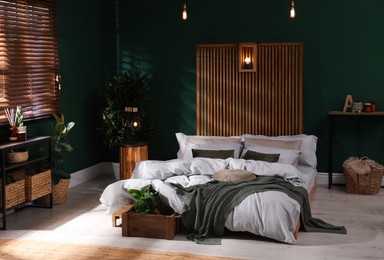 Photo of Stylish interior with large comfortable bed and potted plants