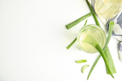 Photo of Fresh aloe drink and leaves on white table, flat lay. Space for text