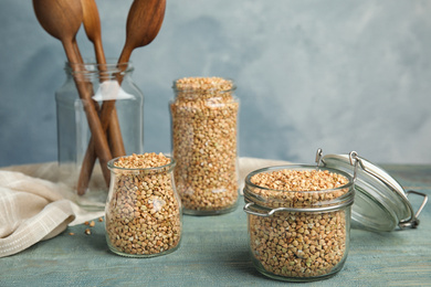 Uncooked green buckwheat grains on light blue wooden table