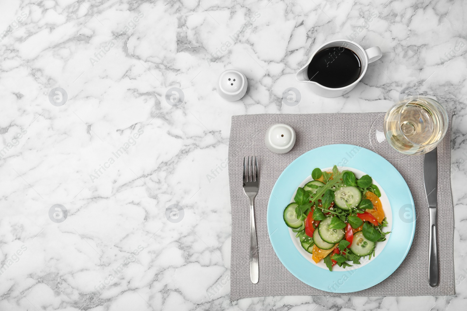 Photo of Vegetable salad and balsamic vinegar served on marble table, top view. Space for text