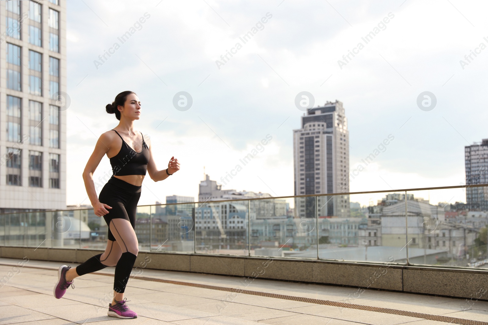 Photo of Beautiful sporty young woman running on street