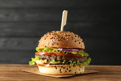 Photo of Burger with delicious patty on wooden table