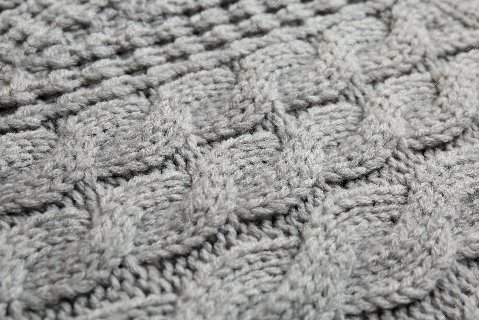 Photo of Grey knitted fabric with beautiful pattern as background, closeup