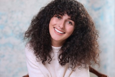 Portrait of happy young woman in stylish sweater on color background