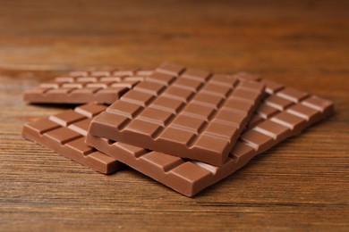 Tasty sweet chocolate bars on wooden table