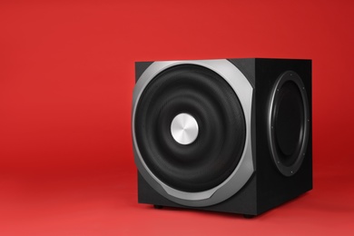 Photo of Modern subwoofer on red background. Powerful audio speaker