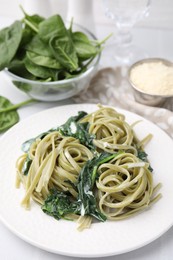 Photo of Tasty pasta with spinach and sauce on white table