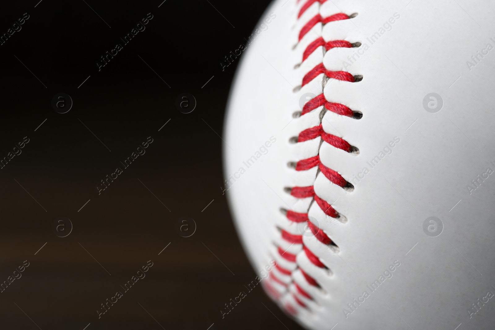 Photo of Closeup view of baseball ball on dark background, space for text. Sportive equipment