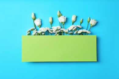 Photo of Empty greeting card with flowers on color background, top view. Space for text