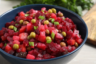 Bowl with delicious fresh vinaigrette salad on table, closeup