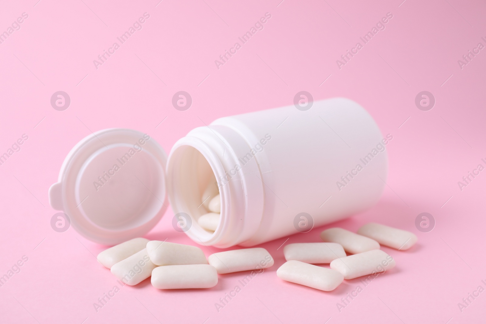 Photo of Jar with chewing gums on pink background, closeup