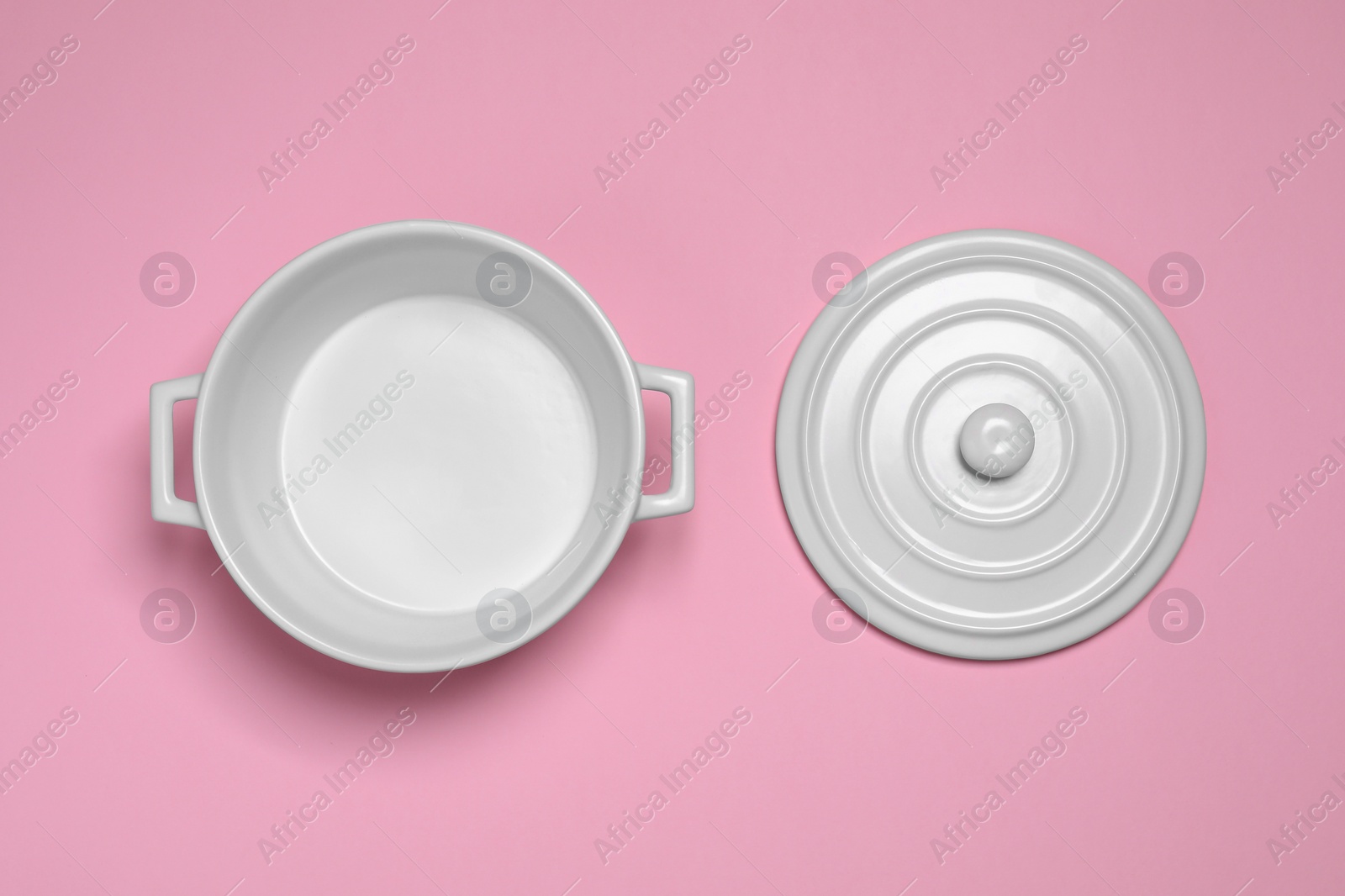 Photo of White pot and lid on pink background, flat lay