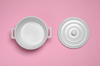 White pot and lid on pink background, flat lay