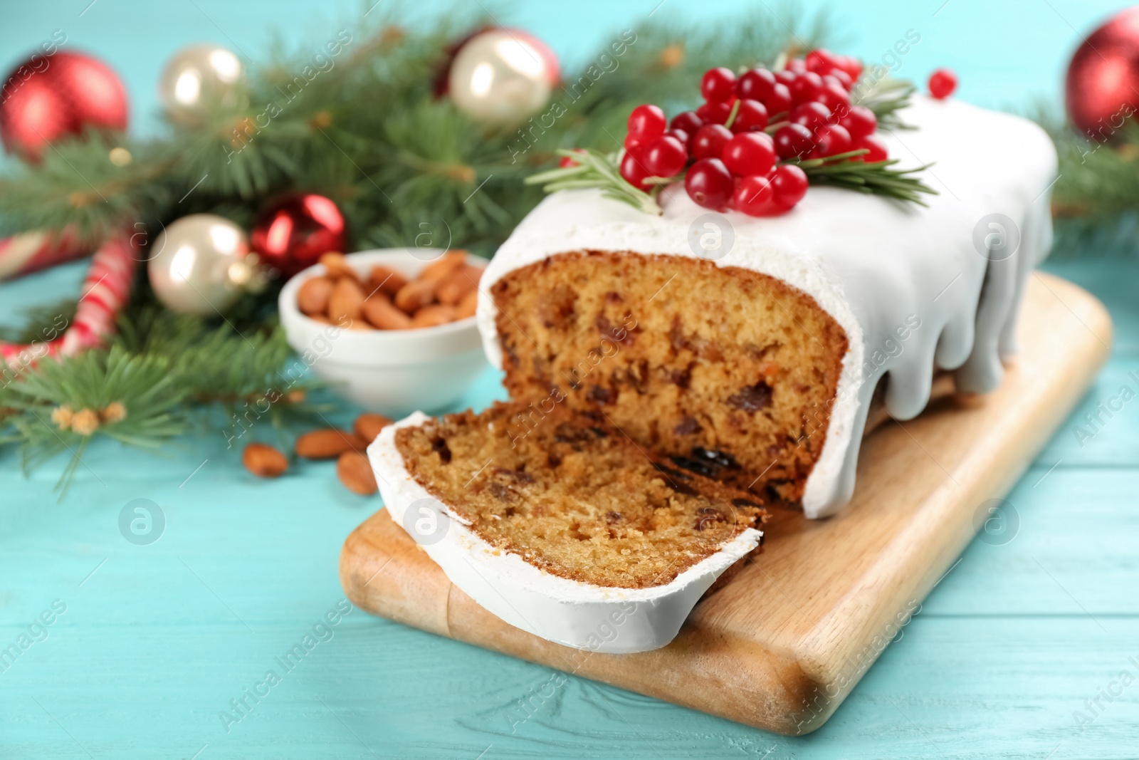 Photo of Traditional classic Christmas cake decorated with cranberries and rosemary on turquoise wooden table