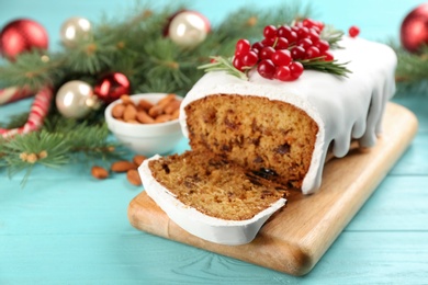 Photo of Traditional classic Christmas cake decorated with cranberries and rosemary on turquoise wooden table