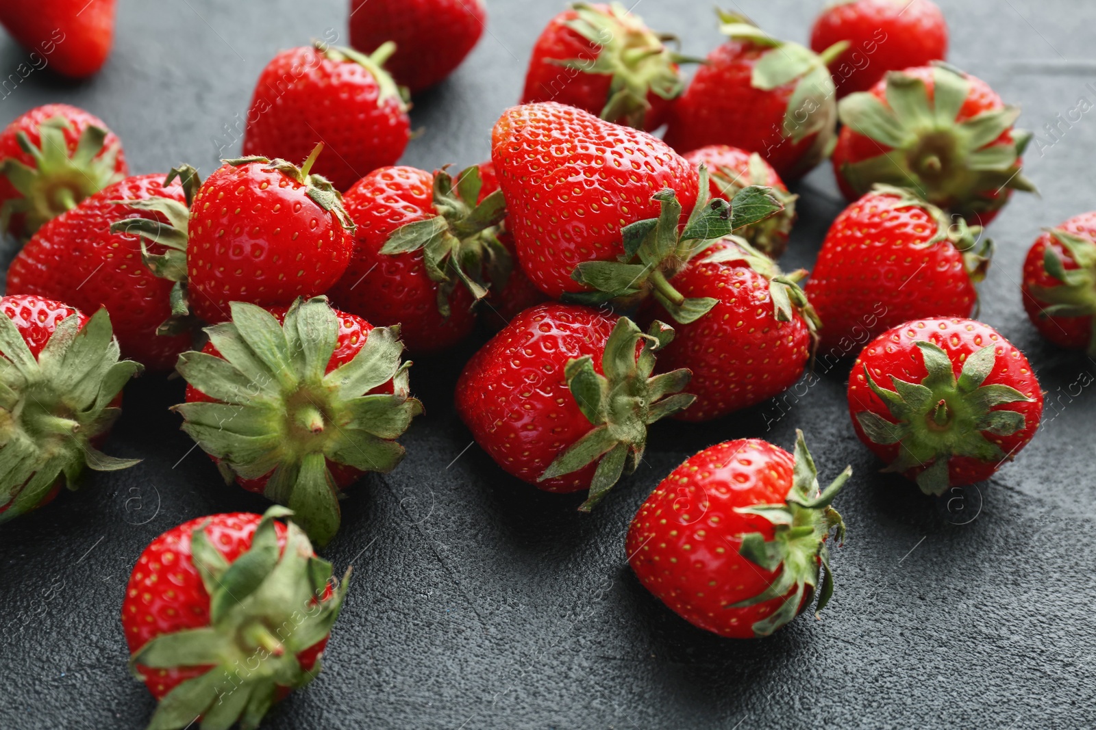 Photo of Ripe red strawberries on black background, closeup