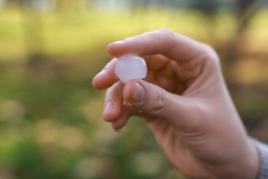Photo of Woman holding hail grain after thunderstorm outdoors, closeup
