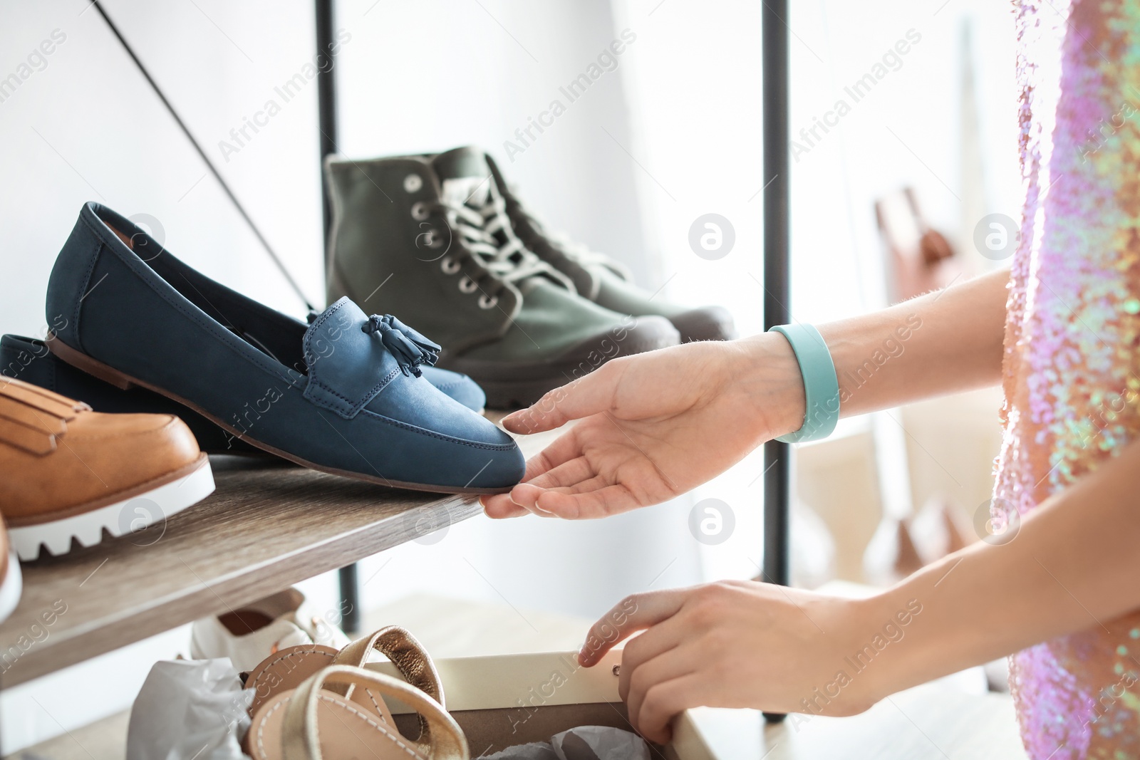 Photo of Young woman choosing shoes in store
