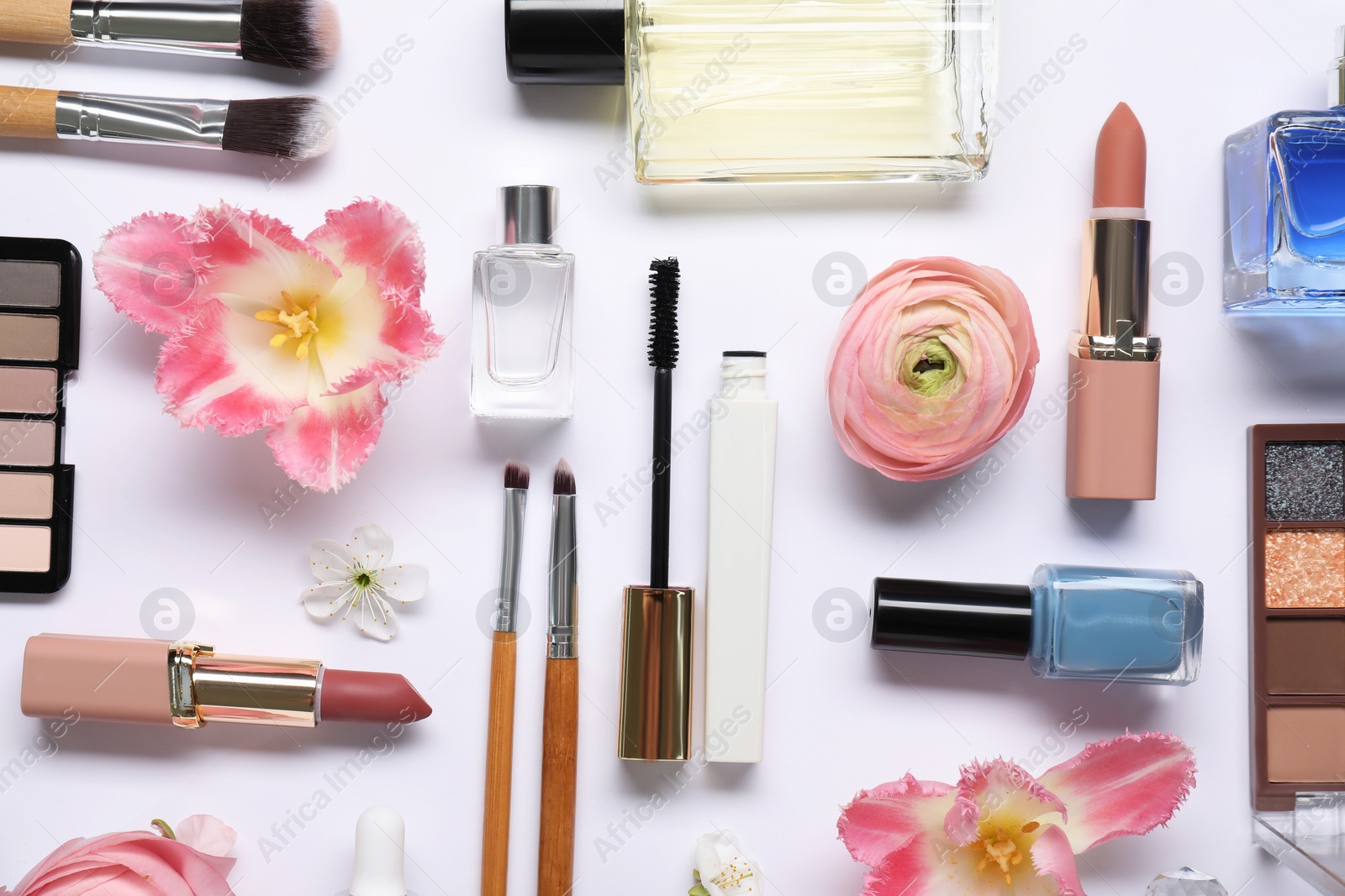 Photo of Flat lay composition with different makeup products and beautiful spring flowers on white background