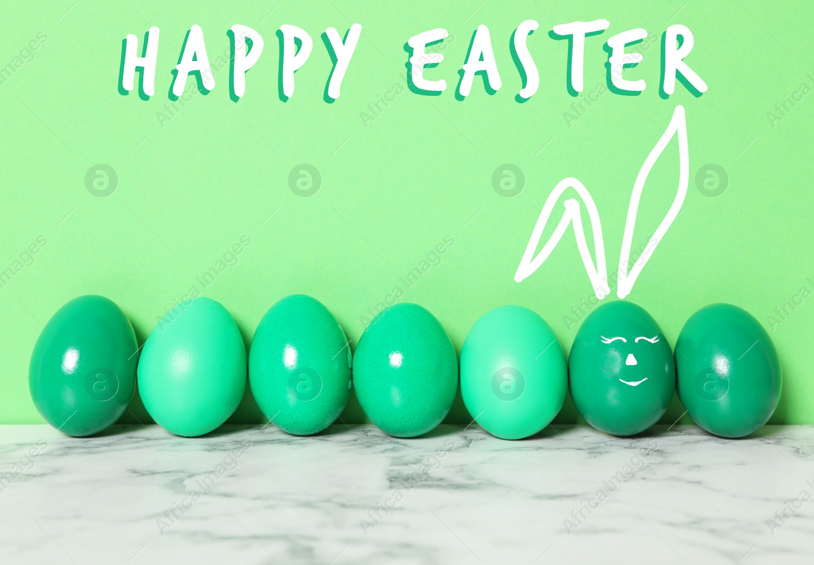 Image of One egg with drawn face and ears as Easter bunny among others on white marble table against green background