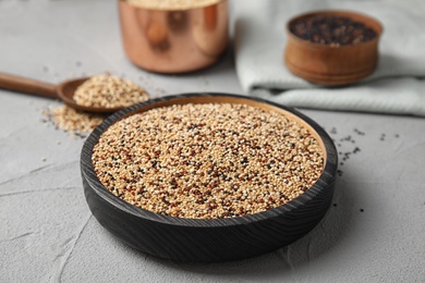 Photo of Plate with mixed quinoa seeds on grey table